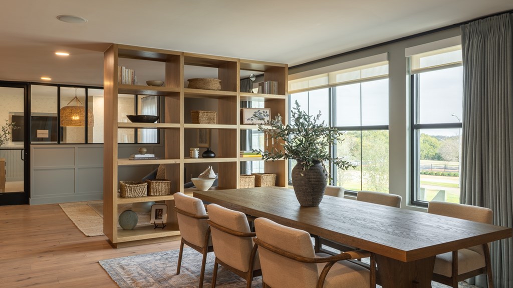 A dining room with a wooden table and chairs.